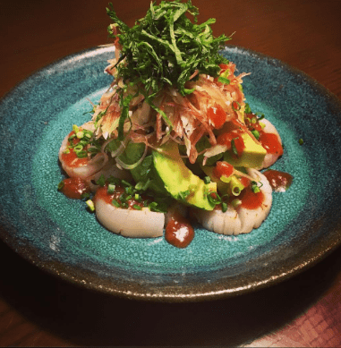 Broiled scallops and avocado topped with fresh herbs